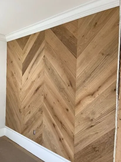 Chevron wood wall paneling completed with consistent angles and seamless transitions.